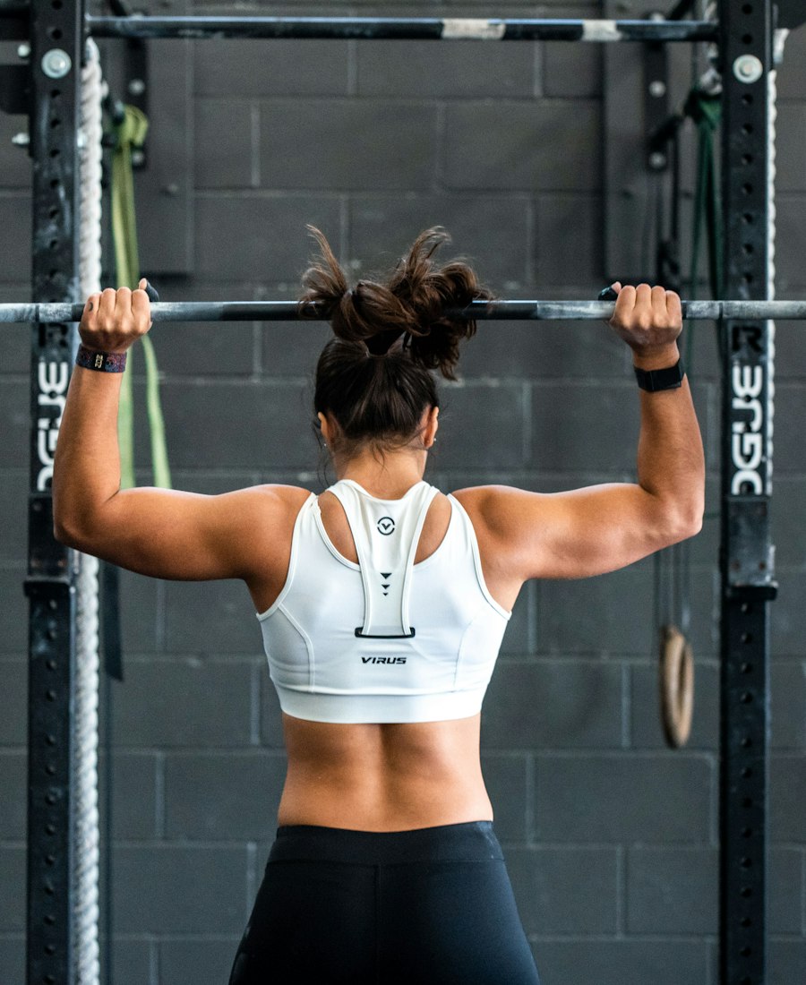 Woman gripping a loaded barbell on a squat rack