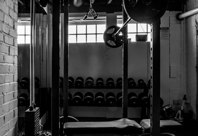 Kettlebells lined up under a squat rack